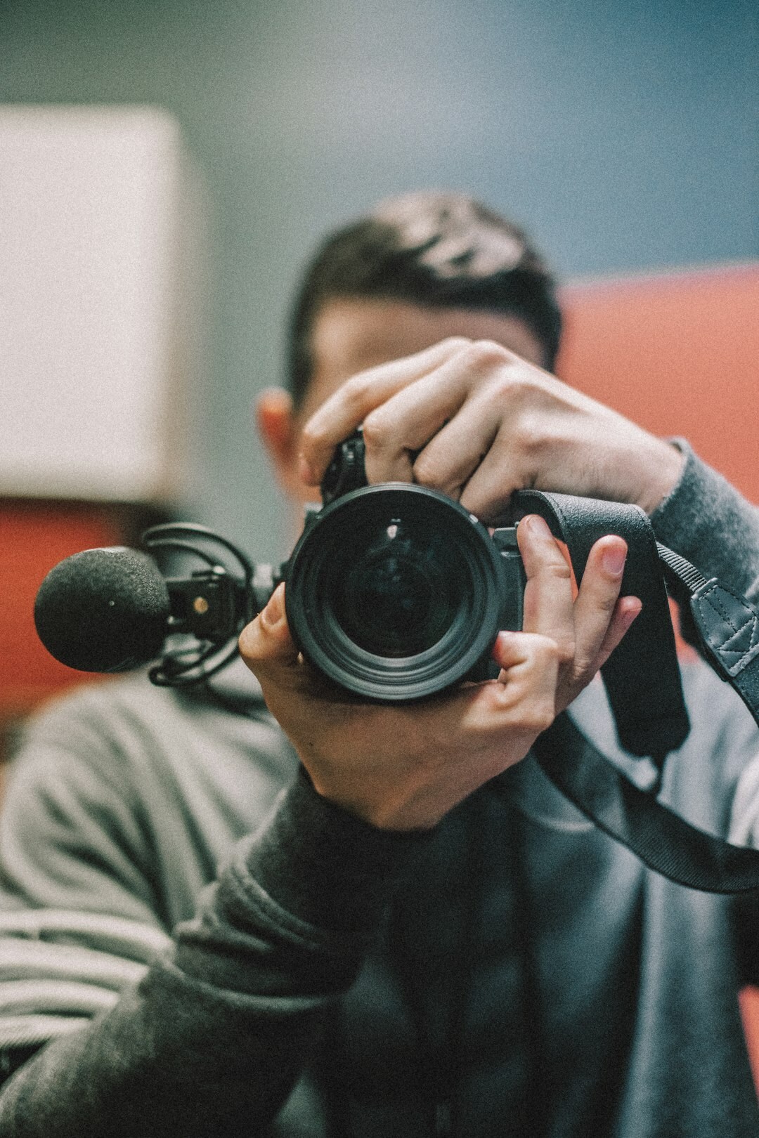 Press photographer holding a professional camera while covering a news event