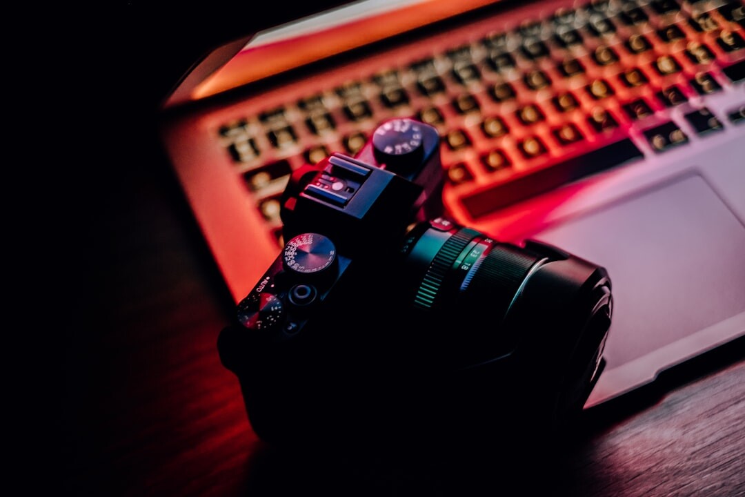 Photojournalist editing photos on a laptop next to a camera