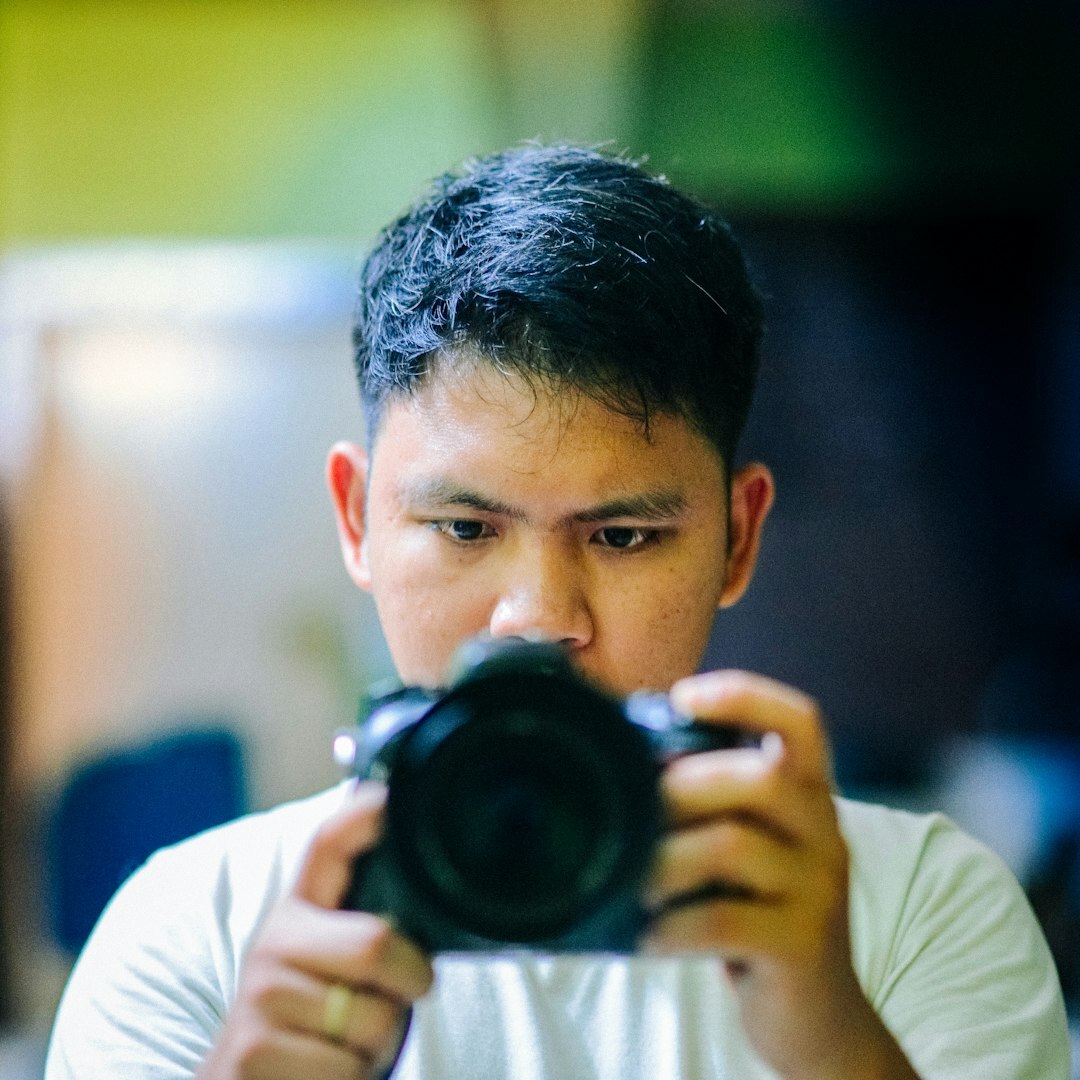 Journalist reviewing photo composition on a camera screen during a training session